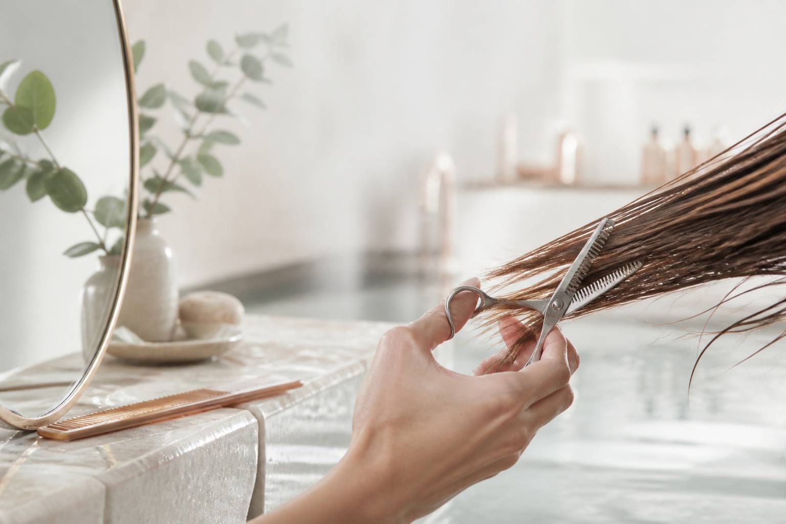 Ciseaux de coiffure effilant une mèche de cheveux bruns
