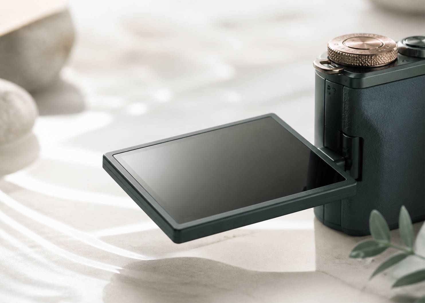 Écran orientable et molette d'un appareil photo compact sur fond clair